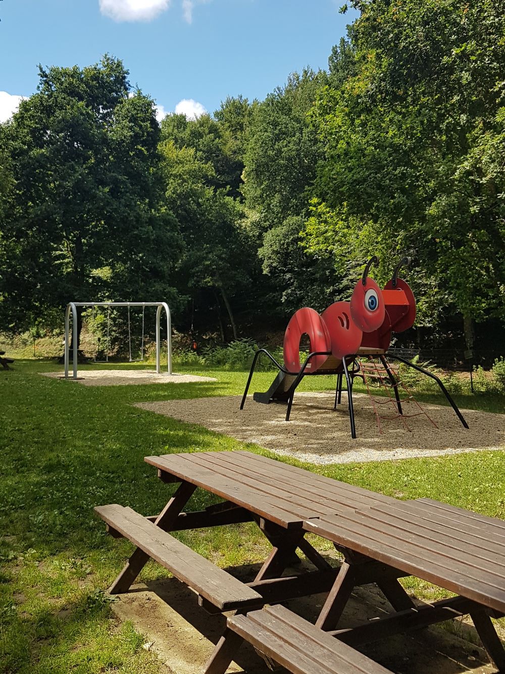 Une aire de jeux avec toboggan, balançoire et tables de pique-nique est mise à disposition.